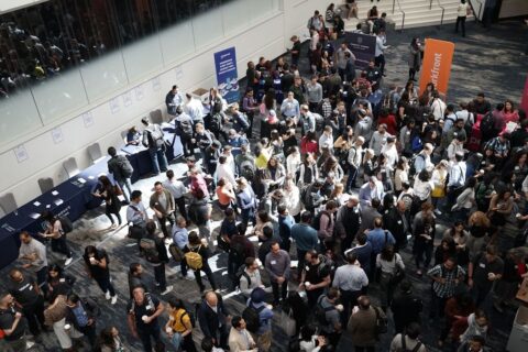 High-angle view of a crowded trade show floor with many attendees.