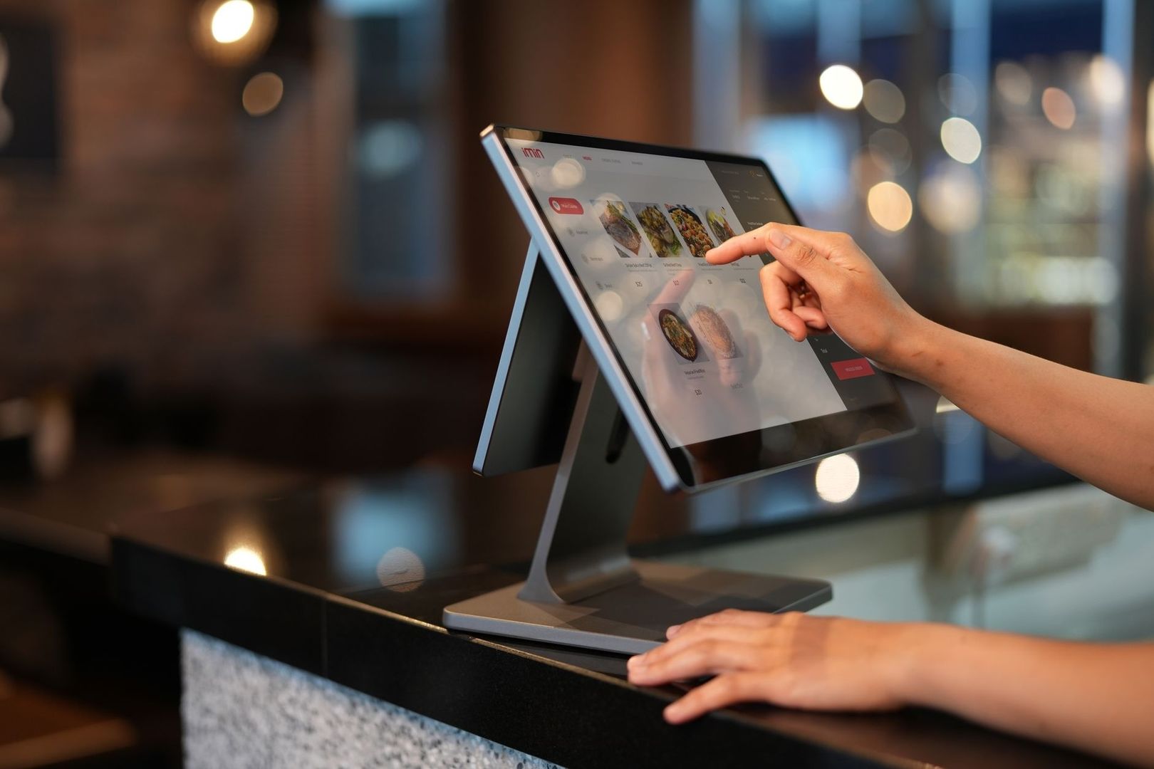 Person taps a touchscreen POS terminal displaying food choices