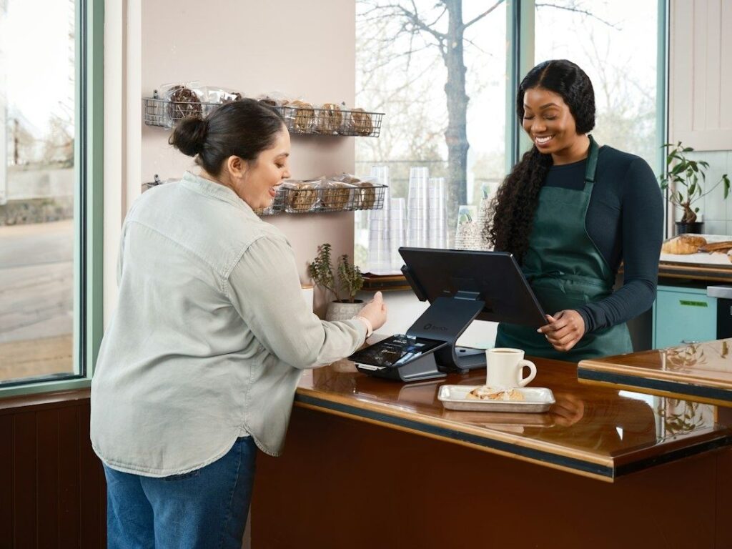 Cashier assists a customer at a retail checkout terminal